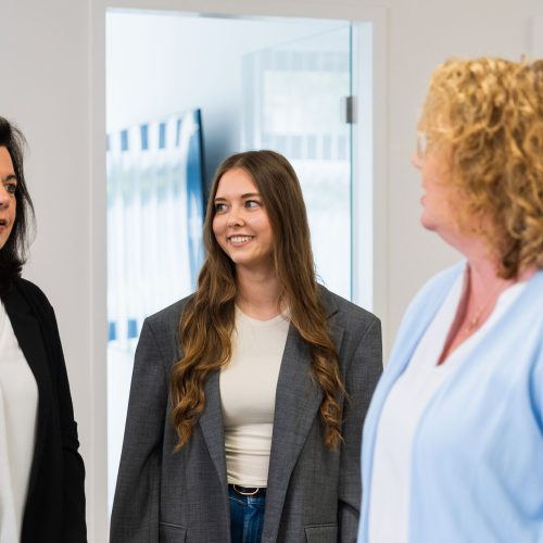 Drei Personen im Gespraech in einem hellen Buero